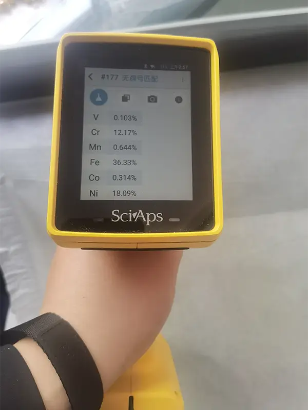 A person measures the chemical composition of the blackened mesh material.
