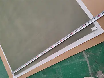 The width of the PTFE coated stainless steel wire mesh sheet is measured to be 105 cm.
