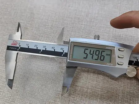 Measure the diameter of irregular stainless steel weave piece with a caliper
