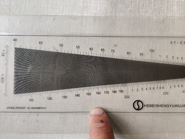 Measure the mesh count of super duplex stainless steel woven mesh with a gauge.
